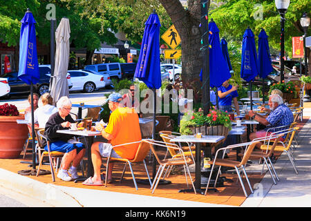 Les gens njoying déjeuner dans un cadre détendu à l'extérieur d'un restaurant dans le centre-ville main Street, Sarasota FL Banque D'Images