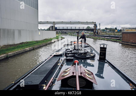 Direction d'un bateau à narrowboat à travers des usines chimiques à Northwich sur le canal Trent et Mersey Banque D'Images