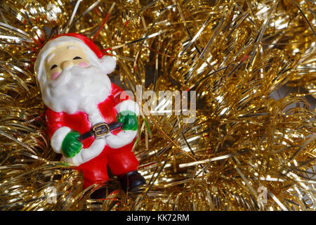 Santa Claus figurine d'or et de guirlandes de décoration pour Noël Banque D'Images