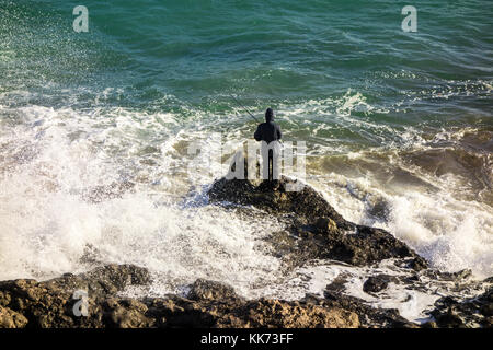 LANZAROTE, ESPAGNE-5 novembre 2017: Un homme pêchant sur les rochers de la côte espagnole, avenue de las Playas à Puerto del Carmen. Banque D'Images