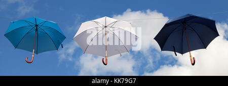 Parasols suspendus en bleu, blanc et bleu foncé. Banque D'Images