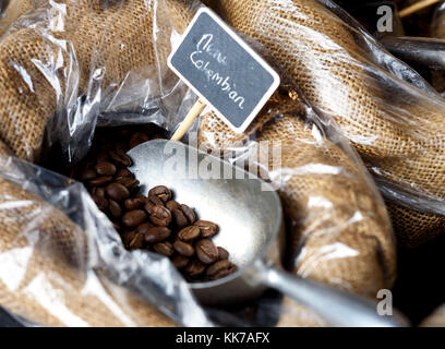 Image de grains de café dans un sac en toile de jute avec une cuillère en argent sur l'affichage à un marché de producteurs Banque D'Images