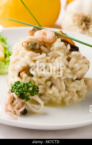 Photo de délicieux risotto aux fruits de mer sur blanc fond isolé Banque D'Images