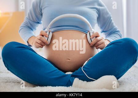 Close up de femme enceinte que la tenue d'un casque Banque D'Images