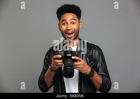 Close-up portrait of happy quitté afro american man photocamera, isolé sur fond gris Banque D'Images