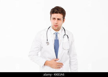 Portrait of a male doctor with stethoscope habillés en uniforme qui souffrent d'un mal d'estomac et à l'écart isolé sur fond blanc Banque D'Images