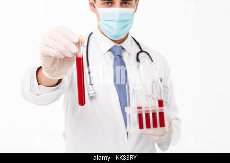 Portrait d'un jeune homme sérieux doctor with stethoscope habillés en tenue uniforme isolé sur fond blanc ampoules Banque D'Images