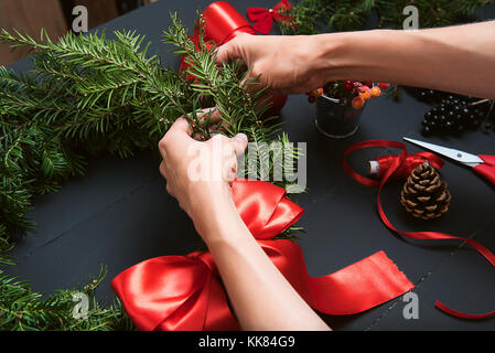 Couronne de noël faisant mains fleuriste Banque D'Images