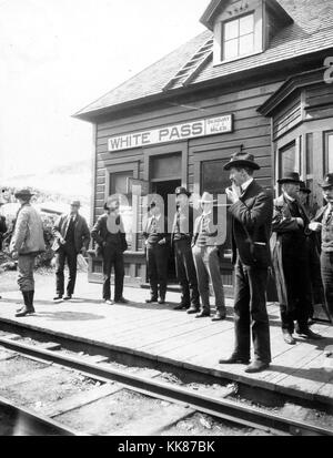 Klondike Goldrush, gentleman et prospecteurs debout à la White Pass and Yukon Railroad Station en Alaska. La station a été un point essentiel pour les prospecteurs à la tête hors de l'or de l'Alaska et du Yukon. Image courtoisie USGS. 1900. Banque D'Images