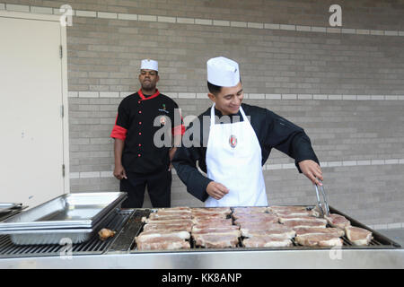 Le sergent d'artillerie. Rudolph Montgomery, chef régimentaire du 14e Régiment de Marines surveille que le Cpl. Christian Fuentes, cuisiniers steaks sur le grill à l'extérieur du hall de la salle à manger, Moreland 8 Novembre 2017 à bord de Naval Air Station Joint Reserve Base Fort Worth, Texas. Le Marine Corps anniversaire repas a été présenté par 14e Régiment de Marines, 4e Division de Marines en l'honneur de toutes les marines locales et pour commémorer le 242ème anniversaire du Corps des Marines. Banque D'Images