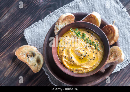 Bol de l'hummus de citrouille avec des tranches de pain grillé Banque D'Images