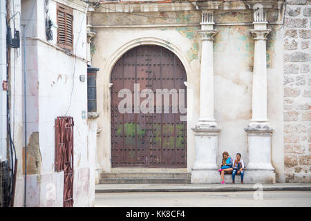 Deux jeunes femmes cubaines attendent devant une vieille église à La Havane, Cuba Banque D'Images