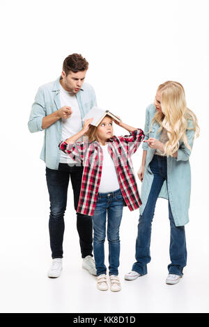 Portrait d'une famille d'avoir et de l'argumentation avec un enfant debout avec un livre isolé sur fond blanc Banque D'Images