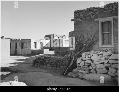 Une photographie en noir et blanc de plusieurs maisons avec une course de rue entre eux, les maisons sont faites de pierre et d'adobe, les poutres utilisées pour soutenir les plafonds peut être vu sortant de certains des toits, l'image provient d'une série de photographies connu comme le projet mural par Ansel Adams, il a été commandé par le National Park Service en 1941 pour créer une fresque photographique pour le ministère de l'intérieur des capacités à Washington DC, le projet a pris fin en raison de la Seconde Guerre mondiale, la maison fait partie d'Acoma Pueblo et a été habitée depuis plus de 800 ans, la réserve indienne de Acoma, Nouveau Mexique Banque D'Images