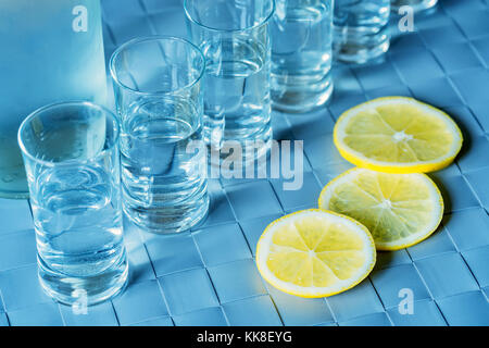 Verre de vodka et citron sur la surface bleue Banque D'Images