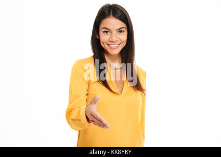 Close-up portrait of pretty young woman in yellow shirt tenant la main pour saluer quelqu'un, isolé sur fond blanc Banque D'Images