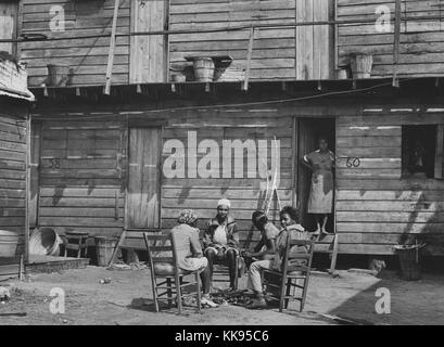 Photographie en noir et blanc avec quatre femmes afro-américaines à l'extérieur des logements pour les travailleurs agricoles, à Pahokee, du lac Okeechobee, en Floride, Février, 1941. À partir de la Bibliothèque publique de New York. Banque D'Images
