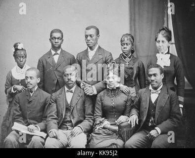 Sepia studio portrait d'un groupe d'hommes afro-américains et les femmes, un coin salon, d'un certain rang, dans des robes et costumes, titré "Chanteurs de l'Université de La Nouvelle-Orléans, de l'aide d'accueil des orphelins de couleur de la Louisiane", 1900. À partir de la Bibliothèque publique de New York. Banque D'Images