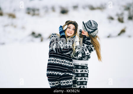 Couple de jeune femme. fille porte chapeau chaud Girl Friend's se ferme les oreilles avec ses mains dans des mitaines en hiver froid Banque D'Images