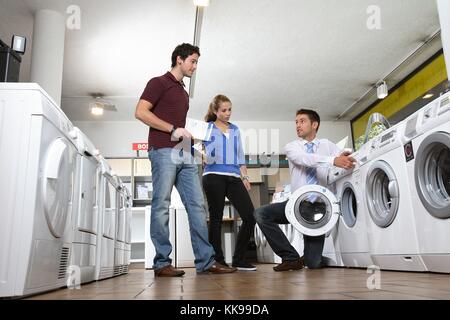 Jeune couple conseil machine à laver | utilisation dans le monde entier Banque D'Images