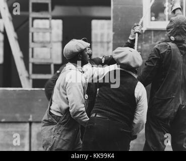 Photographie en noir et blanc d'un groupe de défense d'urgence d'origine afro-américaine, une guerre d'urgence fédérale des États-Unis agence créée pour coordonner les mesures fédérales et d'état pour la protection des civils en cas de guerre, les travailleurs de la construction d'urgence tirant sur une corde, Washington, DC, décembre, 1941. À partir de la Bibliothèque publique de New York. Banque D'Images