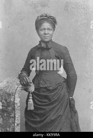 Sepia studio portrait d'une femme afro-américaine, de trois quarts, portant un chapeau et des gants et robe avec agitation, 1875. À partir de la Bibliothèque publique de New York. Banque D'Images