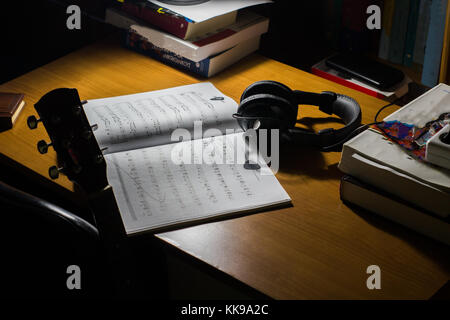 Feuille de musique guitare et casque sur un bureau et livres musique Banque D'Images