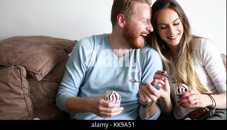 Romantic couple eating ice cream ensemble et regarder la télévision Banque D'Images