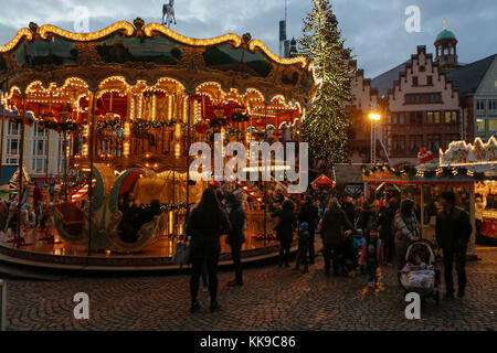 Francfort, Allemagne. 28 novembre 2017. Les passants regardent un carrousel pour enfants à l'ancienne sur la place centrale de Römerberg avec l'hôtel de ville médiéval (Römer) en arrière-plan. Le marché de Noël de Francfort, l'un des plus anciens marchés de Noël d'Allemagne, se tient chaque année à l'époque de l'Avent. Il est également, avec environ 3 millions de visiteurs, l'un des plus grands marchés de Noël en Allemagne. Crédit: Michael Debets/Pacific Press/Alay Live News Banque D'Images