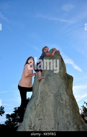 Deux enfants à grimper, garçon détient sur au point d'un kletter - rock, directement sous lui de fille Banque D'Images