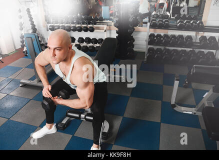 Strong athletic hommes muscles et de pompage jusqu'à la séance de gym bodybuilder. man doing biceps exercice avec haltère dans fitness club Banque D'Images