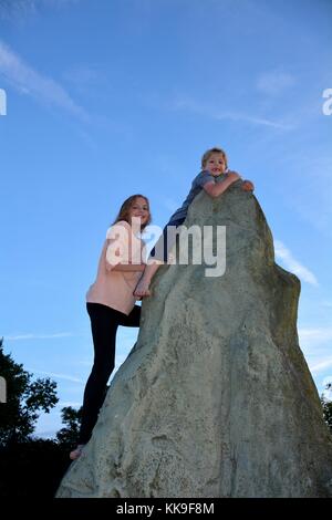 Deux enfants à grimper, garçon détient sur au point d'un kletter - rock, directement sous lui de fille Banque D'Images