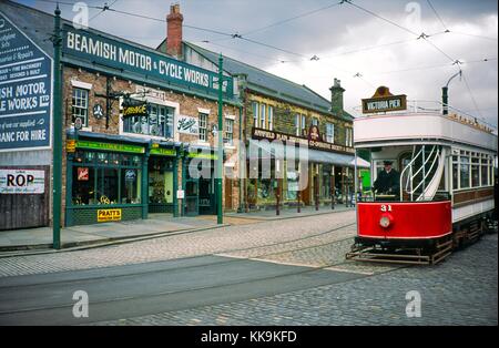 Beamish Museum, County Durham, Angleterre. Tramway électrique vintage boutique garage passant dans la ville avant 1913. Banque D'Images