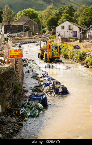 Mois après le village a subi de graves inondations, le dragage de Glenridding Beck continue dans le massif de l'opération de déminage en Cumbria England UK Banque D'Images