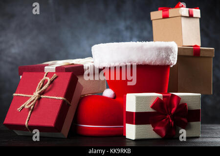 Santa's shoe avec coffrets cadeaux sur fond sombre Banque D'Images