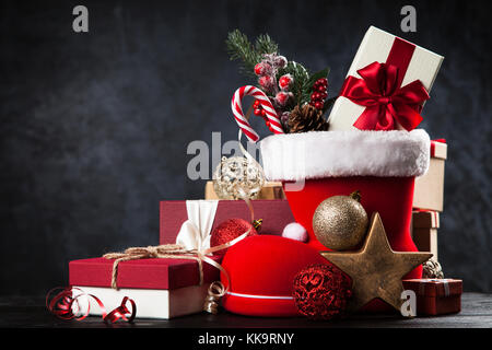 Santa's shoe avec coffrets cadeaux sur fond sombre Banque D'Images