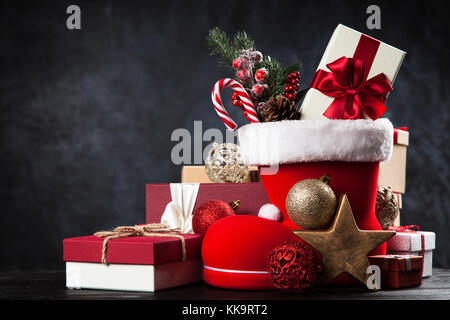 Santa's shoe avec coffrets cadeaux sur fond sombre Banque D'Images