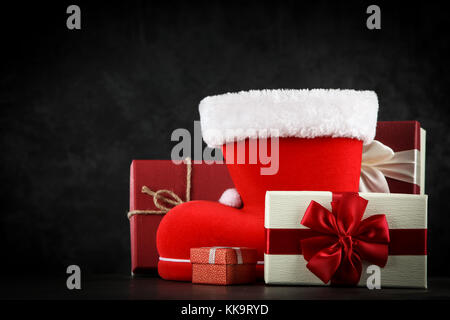 Santa's shoe avec coffrets cadeaux sur fond sombre Banque D'Images