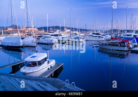 Hibernation en marina d'Aker Brygge, Oslo, Norvège. yachts sont scellées à l'amarrage des jetées flottantes, avec la forteresse à l'arrière-plan. Banque D'Images