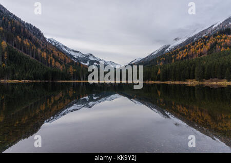 Couleur d'automne forêt et montagnes couvertes de neige se reflétant dans les eaux froides de ingeringsee Banque D'Images