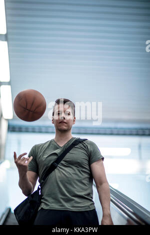 Un homme marchant sur un escalier avec un terrain de basket-ball dans la main. Low angle shot. Banque D'Images