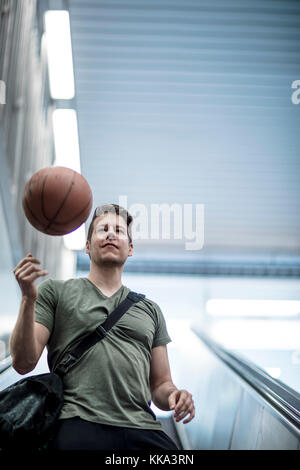 Un homme marchant sur un escalier avec un terrain de basket-ball dans la main. Low angle shot. Banque D'Images
