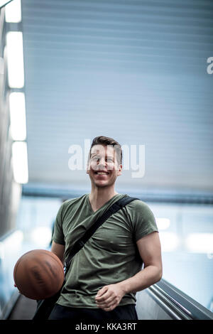 Un homme marchant sur un escalier avec un terrain de basket-ball dans la main. Low angle shot. Banque D'Images