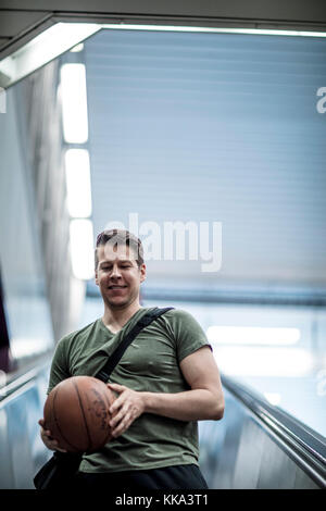 Un homme marchant sur un escalier avec un terrain de basket-ball dans la main. Low angle shot. Banque D'Images