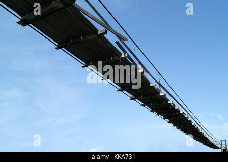 Vue de dessous sur un vieux pont suspendu en bois sur un fond de ciel Banque D'Images