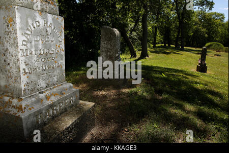 Iowa, États-Unis. 6 juin 2017. Le minuscule cimetière de Sandy point, situé sur le côté sud de Harpers Ferry, est entouré d'une clôture en fer noir et d'immenses chênes. Un homme d'affaires influent de l'Iowa connu pour son importante entreprise de merchandising qui a acheté et expédié des produits et après qui la ville de Harpers Ferry a été nommée en 1860. Plus d'un siècle plus tard, M. Harper est toujours considéré comme un esprit de premier plan dans le développement de cette communauté fluviale et sa pierre tombale demeure dans la grandeur digne. Mais la tombe de Harper qui entoure: seve Banque D'Images