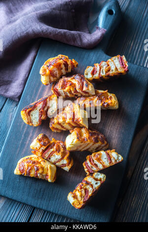 Rouleaux de pizza sur la planche de bois Banque D'Images