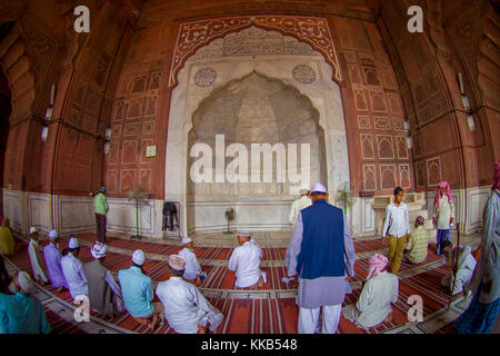 Delhi, Inde - 27 septembre 2017 : groupe non identifié d'hommes assis dans le sol et priant à la mosquée Jama Masjid à l'intérieur du temple de Delhi, Inde, effet oeil de poisson Banque D'Images