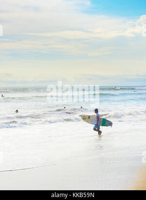 Canggu, BALI, INDONÉSIE - jan 19, 2017 : surfer passe à surfer dans l'océan. L'île de Bali est l'une des meilleures au monde destinations surf Banque D'Images