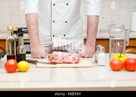 Male chef de la préparation pour la cuisson du porc filet à une cuisine de restaurant. Banque D'Images